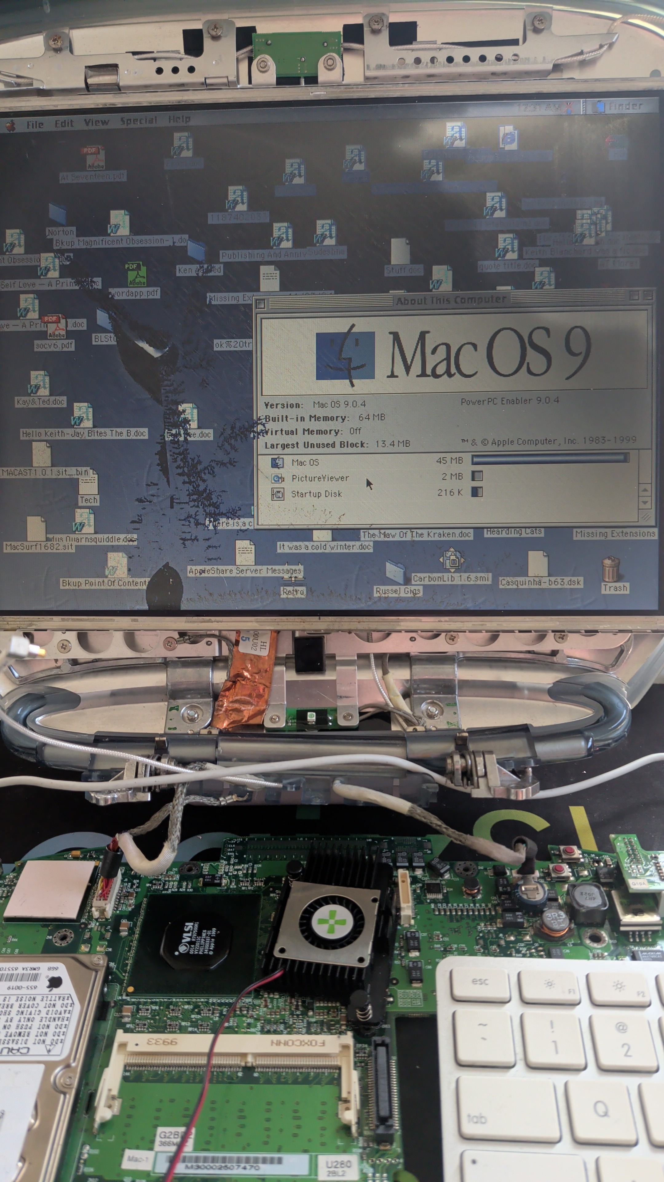 Mac OS 9.2.1 running bare on the bench, desktop covered in old files